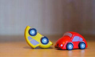 Punainen ja keltainen leluauto kolarissa