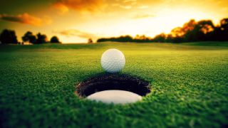 Golf-pallo viheriöllä lähellä reikää