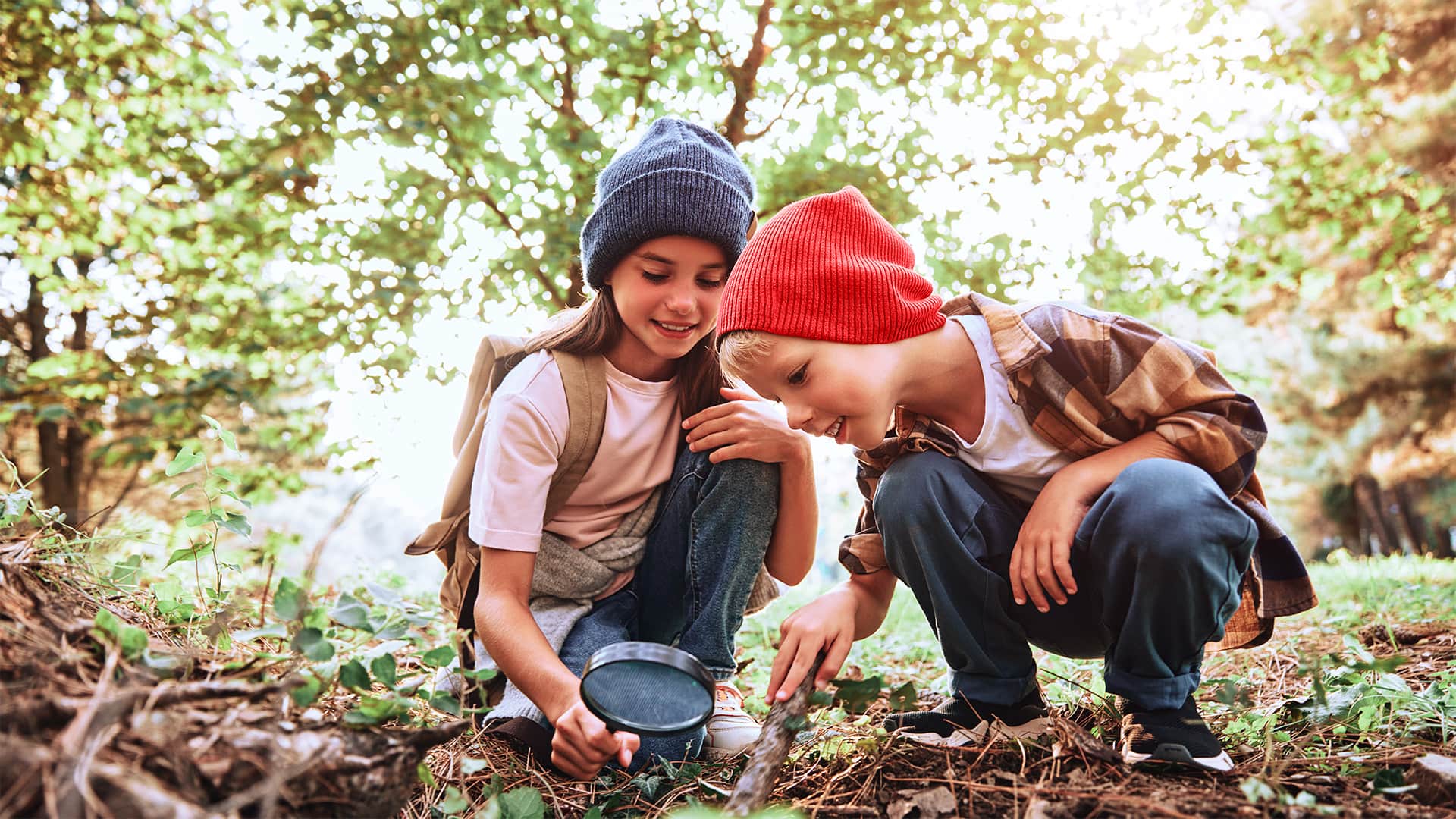 Lapset metsässä tutkimassa maaperää.