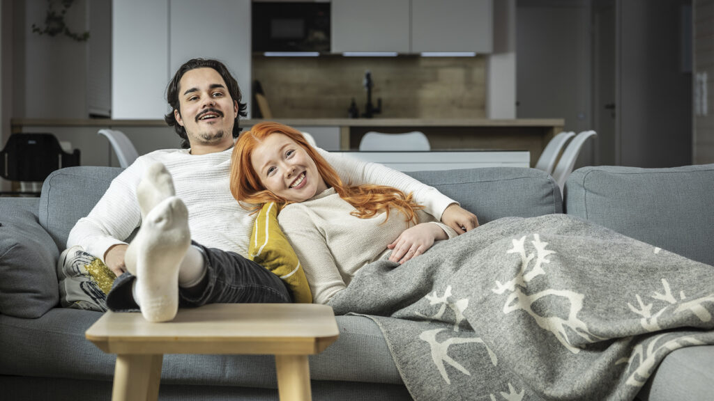 mies ja nainen lepäävät sohvalla sylikkäin
