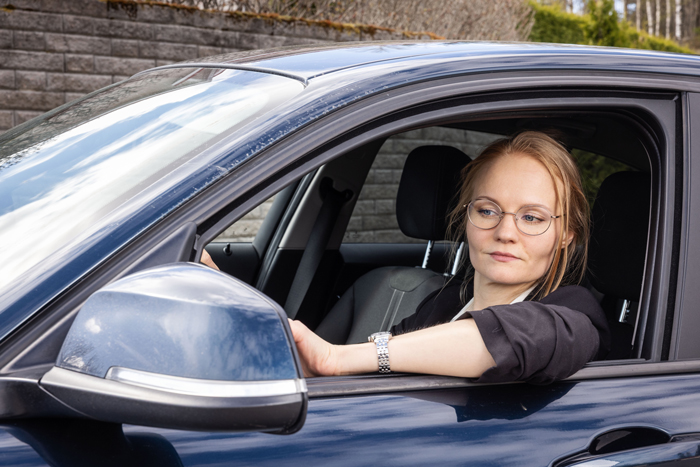 nainen istuu autossa